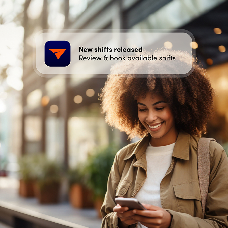 Employee happily receiving a new shift notification on the Elevate mobile app, showcasing the benefits of staff scheduling software for easy booking and less admin