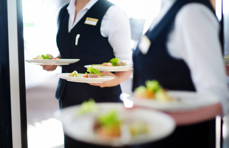 Waiting staff with food at a hospitality event, showcasing how Elevate staff scheduling software enhances guest experience and coordination.