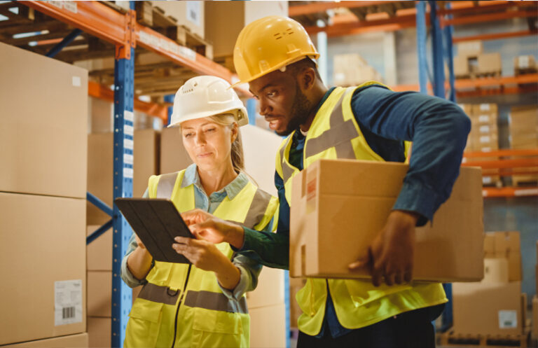 Two warehouse workers using Elevate labour management system on a tablet, streamlining logistics and workforce control for fulfilment