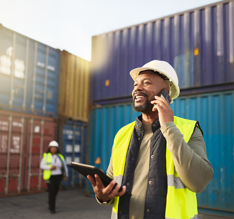 Happy port worker on phone, representing a transformed workforce empowered by Elevate labour management system.