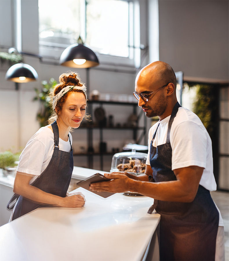 Hospitality staff in a hotel coffee shop using the Elevate workforce management app, highlighting enterprise features for seamless operations.